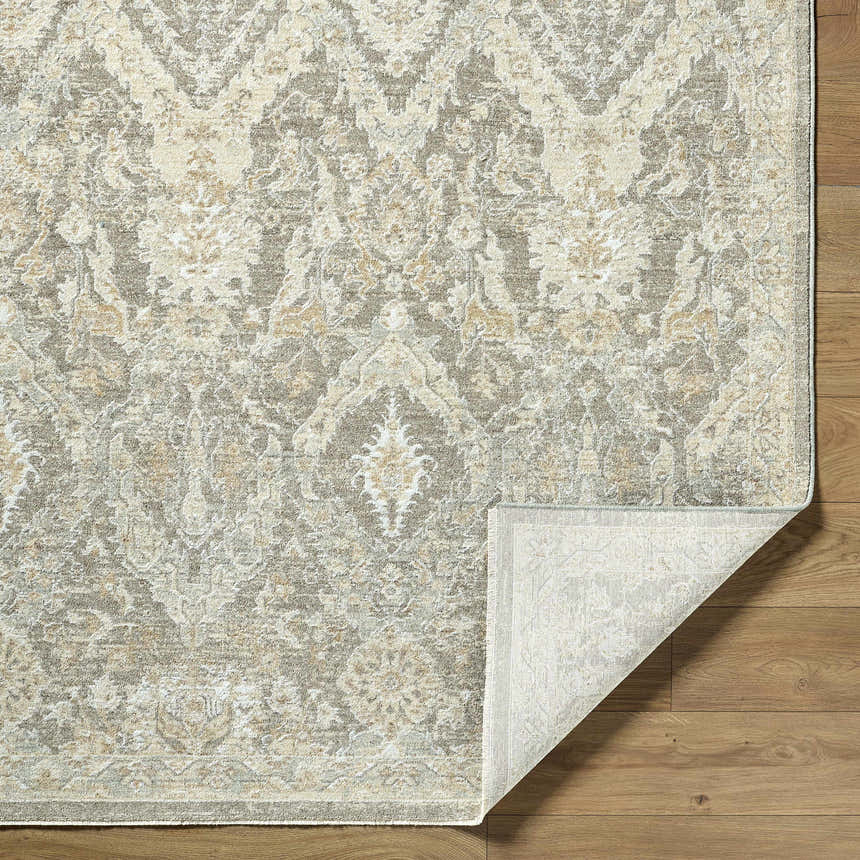 Close-up of the Almaas Medium Gray rug showing its traditional pattern, luxe texture, and folded corner on wood floor. Fold