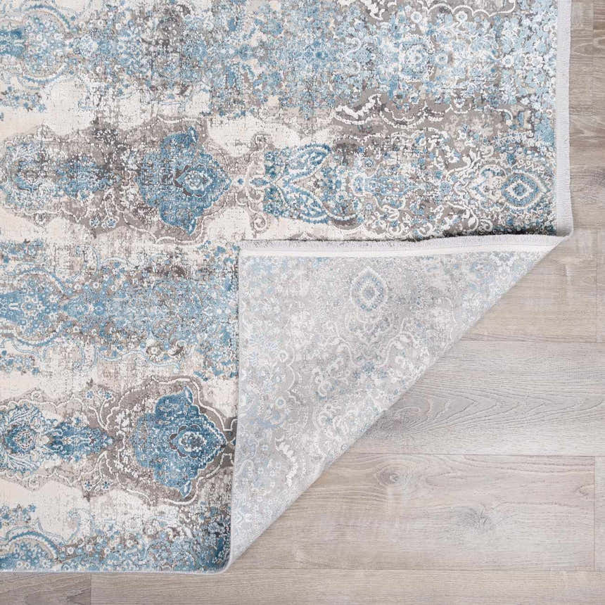 Close-up of the Rydalmere Luxury Ultra Soft Rug in teal and gray, showing the ornate pattern and soft texture. Fold