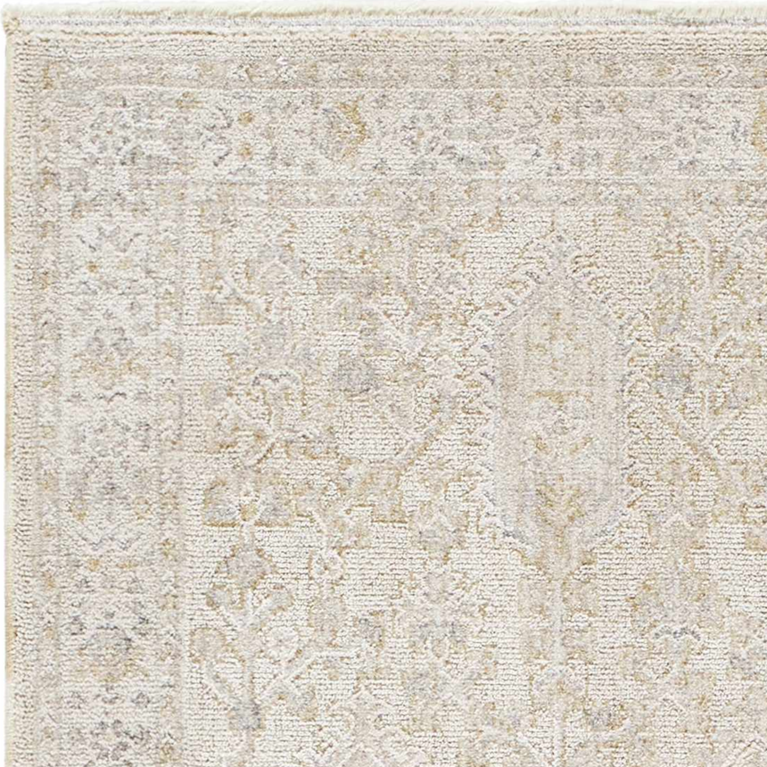 Close-up of the Rafee Tan Luxe Area Rug, showcasing its traditional pattern and soft cream, tan, and gray colors. Texture