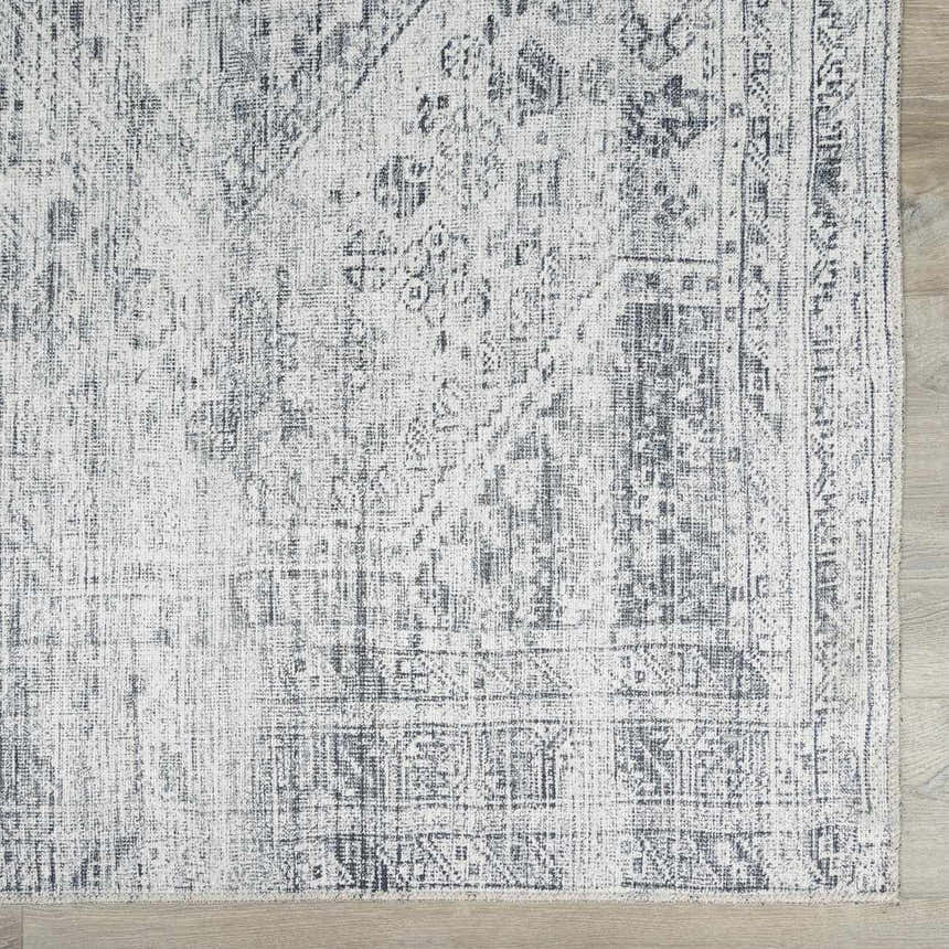 Close-up of the Barny Gray Blue Washable Rug, showcasing its traditional pattern, gray and off-white tones, and soft chenille texture. Swatch