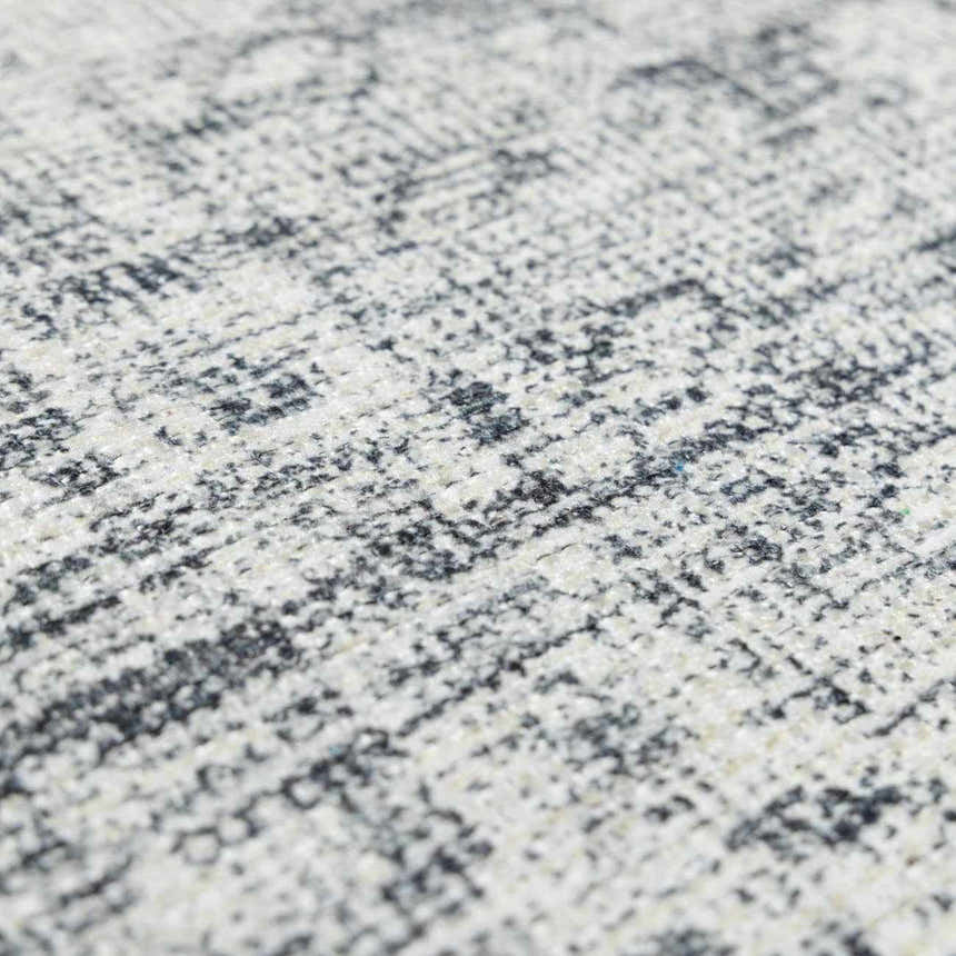 Close-up of the Barny Gray Blue Washable Rug showing its charcoal and off-white distressed pattern and soft chenille texture. Texture