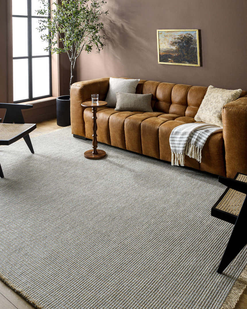 Living room with a brown leather sofa and Kimi Machine Woven Becki Owens rug in gray and light brown. Roomscene-Rectangle