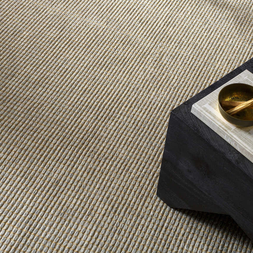 Close-up of the Kimi Becki Owens x LIVABLISS rug. Gray and light brown jute with a woven texture. Styleshot