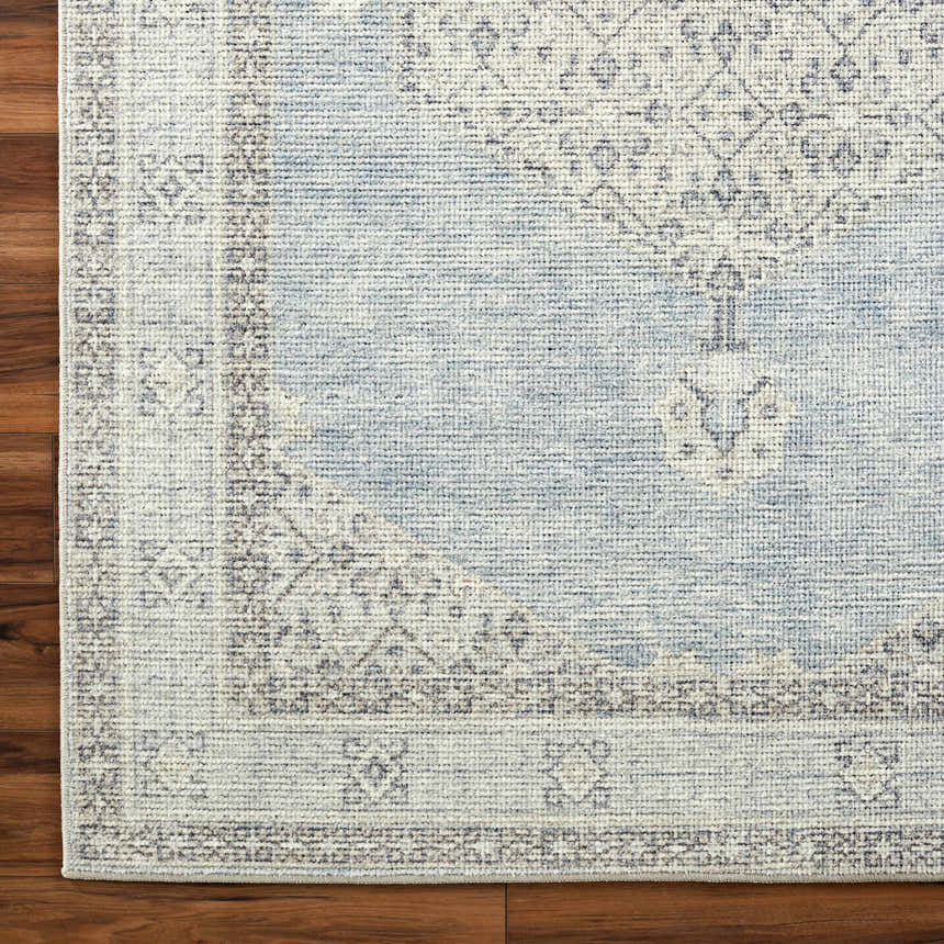 Close-up of the Lila Medallion Denim Area Rug showing its farmhouse style medallion pattern and soft charcoal and gray tones. Corner