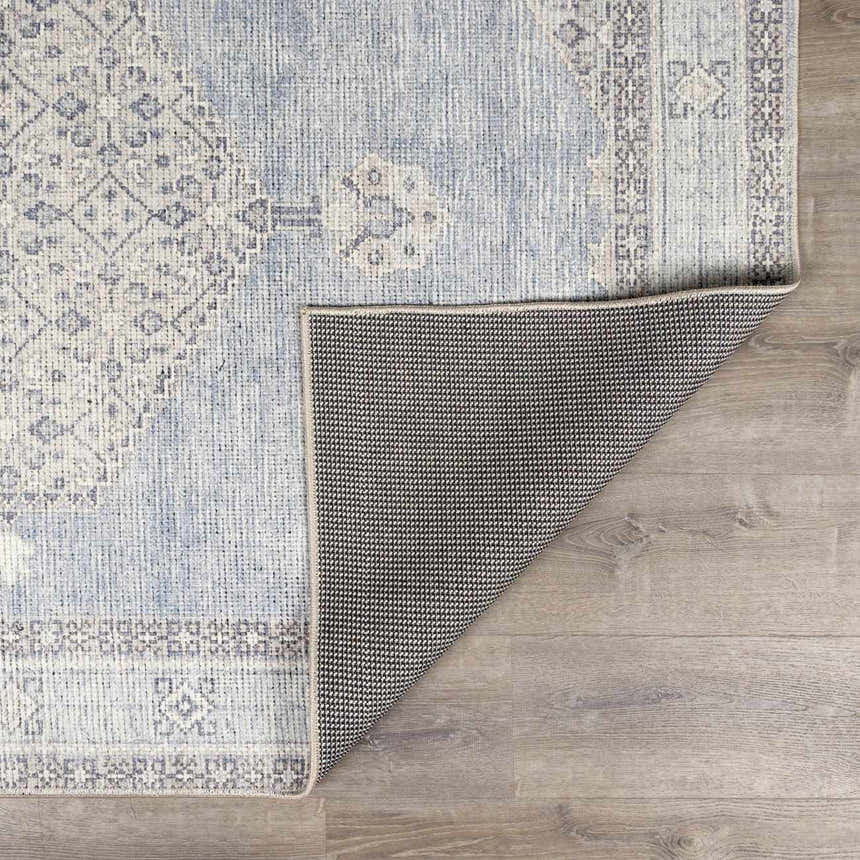 Close-up of the Lila Medallion Denim Area Rug showing its farmhouse style, medallion pattern, and gray, blue, and nutmeg hues. Fold