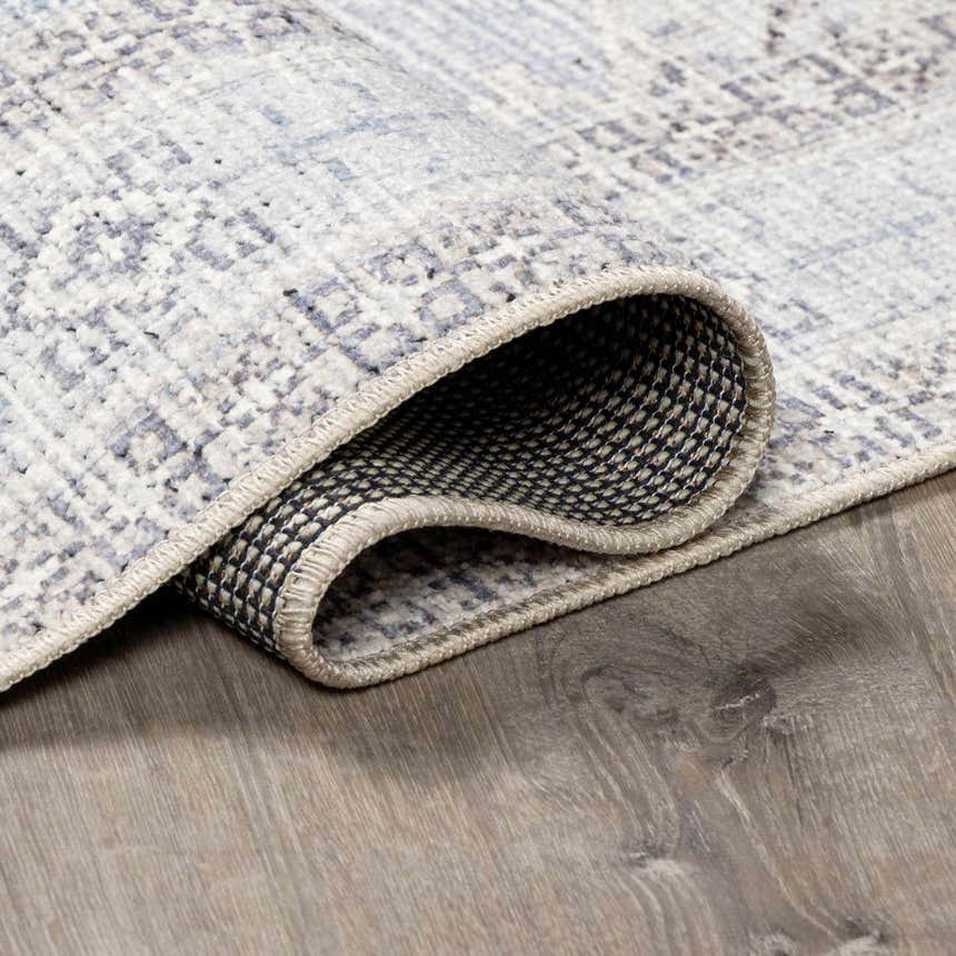 Close-up of the Lila Medallion Denim Area Rug showing the medallion pattern, charcoal, gray, and denim colors. Fold