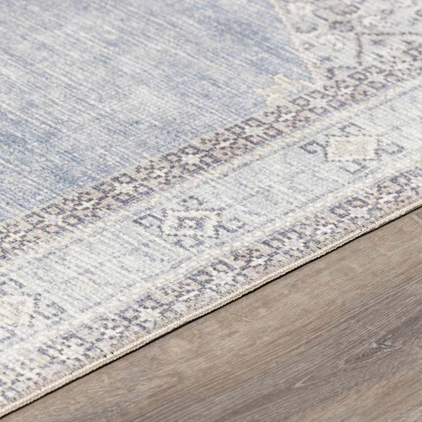 Close-up of the Lila Medallion Denim Area Rug showing its charcoal, gray, and nutmeg traditional pattern and soft texture. Pile