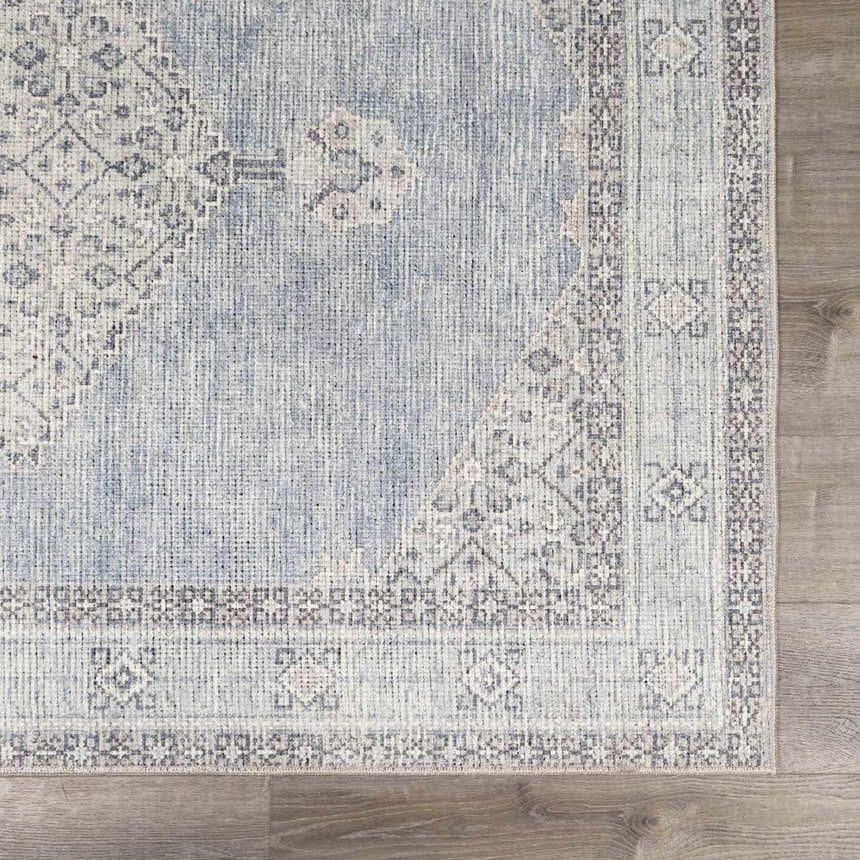 Close-up of the Lila Medallion Denim Area Rug. Farmhouse style rug with charcoal, gray, and nutmeg medallion pattern. Swatch