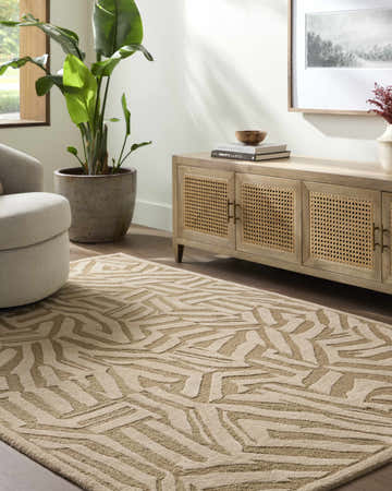 Living room scene with a beige swivel chair and a tan Avian Tan Area Rug with a geometric pattern. Roomscene-Rectangle