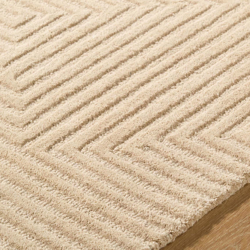 Close-up of the hand-tufted Citro Beige Area Rug. The wool rug has a geometric, raised-line pattern and plush texture. Texture