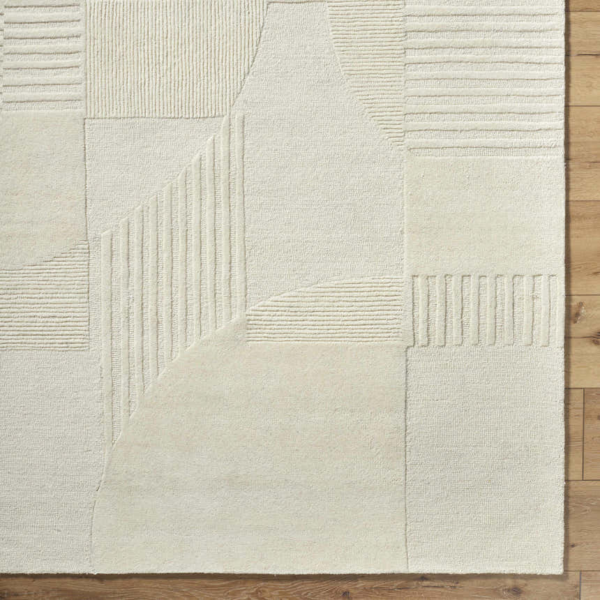 Close-up of the Denis Area Rug. Lambswool-colored wool rug with a contemporary geometric pattern and textured design. Corner