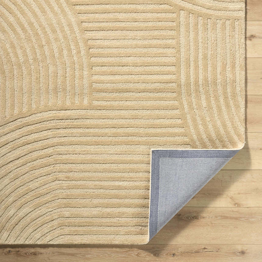 Close-up of the beige Whan Area Rug showing its hand-tufted texture and contemporary linear and curved pattern. Fold