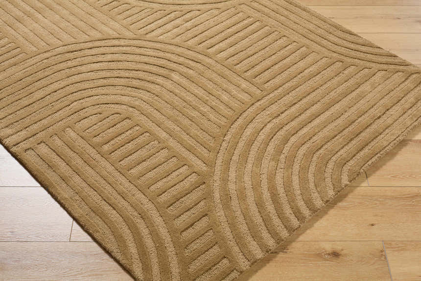 Close-up of the hand-tufted Whan Camel Area Rug, showcasing its contemporary geometric pattern and soft wool texture. Corner