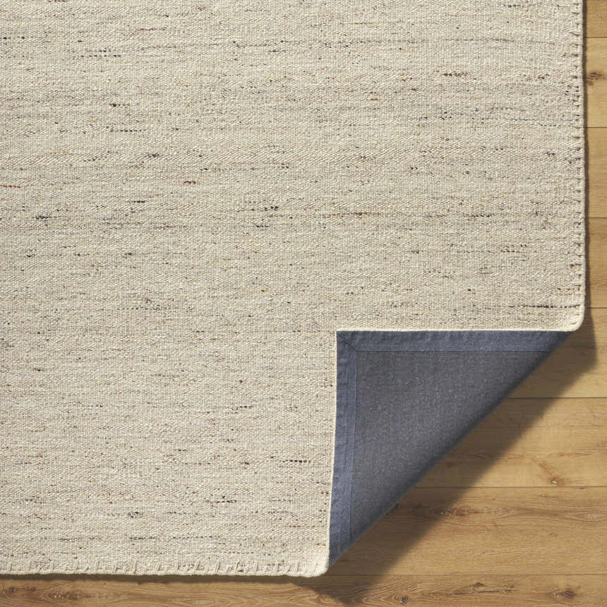 Close-up of the hand-woven Ayumu Sandstone Area Rug. The wool rug has ivory, sandstone, and taupe tones. Fold