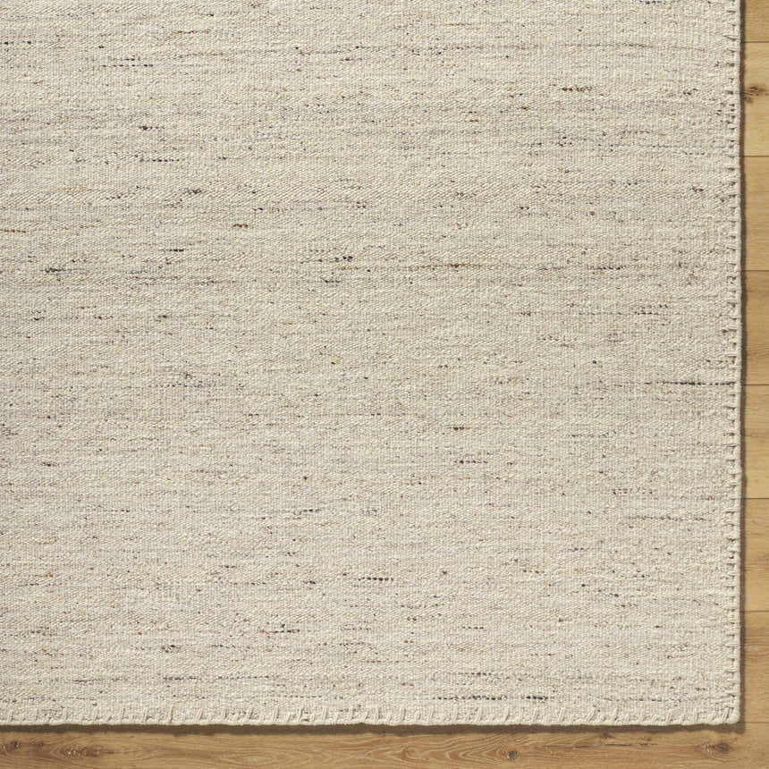 Close-up of the hand-woven Ayumu Sandstone Area Rug. Ivory, sandstone, and taupe wool fibers create a textured, neutral design. Corner
