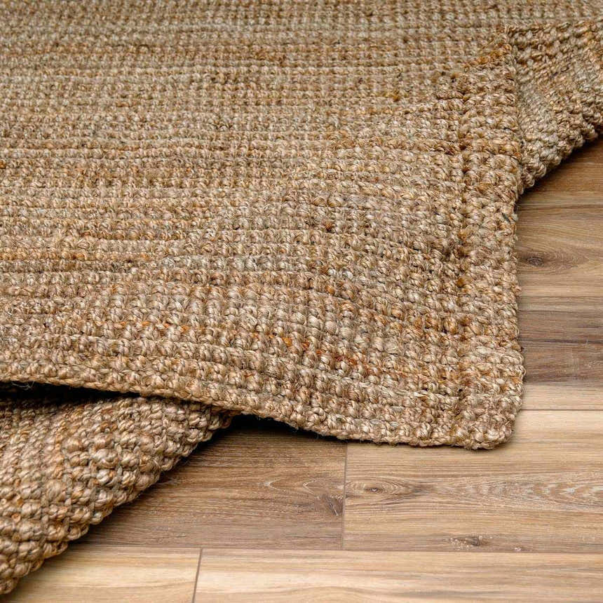 Close-up of a hand-woven Ambel Chocolate Brown Camel Jute Area Rug showing its texture and natural jute color variations. Fold