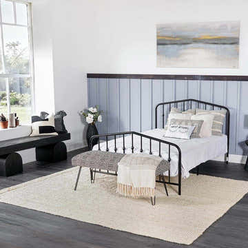 Bedroom scene with Ambel Cream Jute Rug, black metal bed, and bench. Farmhouse style with neutral tones. Roomscene-Rectangle