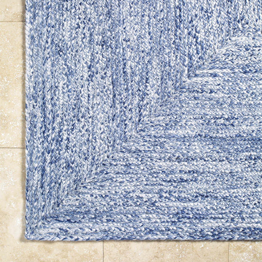 Close-up of the hand woven Kenyi Navy Area Rug showing the texture and pattern of the navy and white recycled yarn. Corner