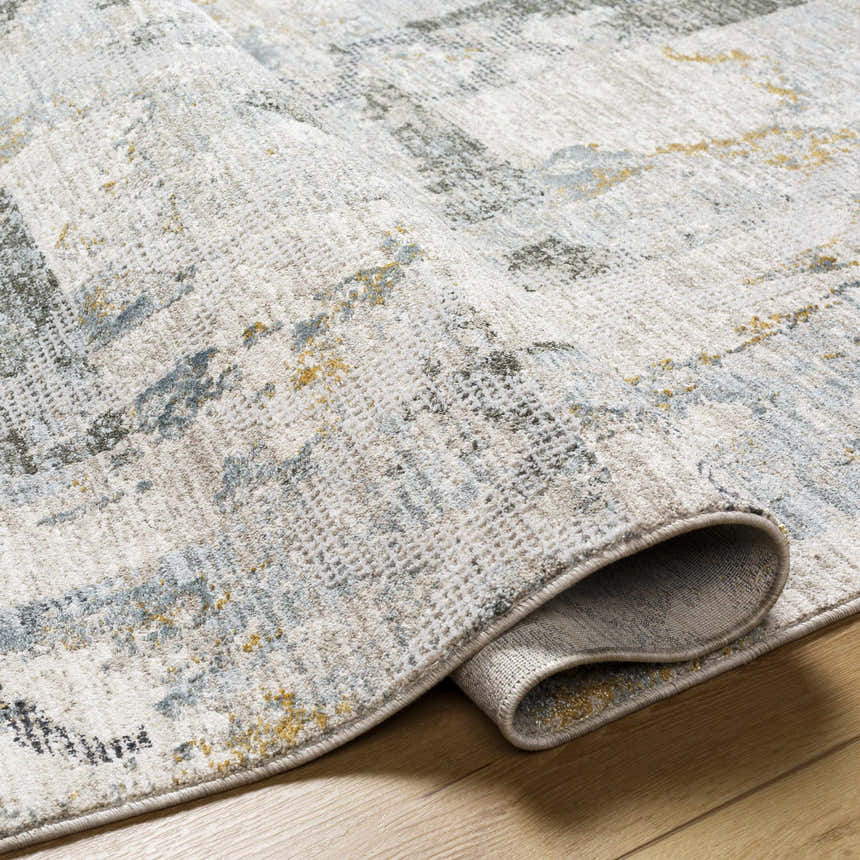 Close-up of the Adlai Textured Rug showing the light gray, ink blue, and mustard colors and textured weave. Fold