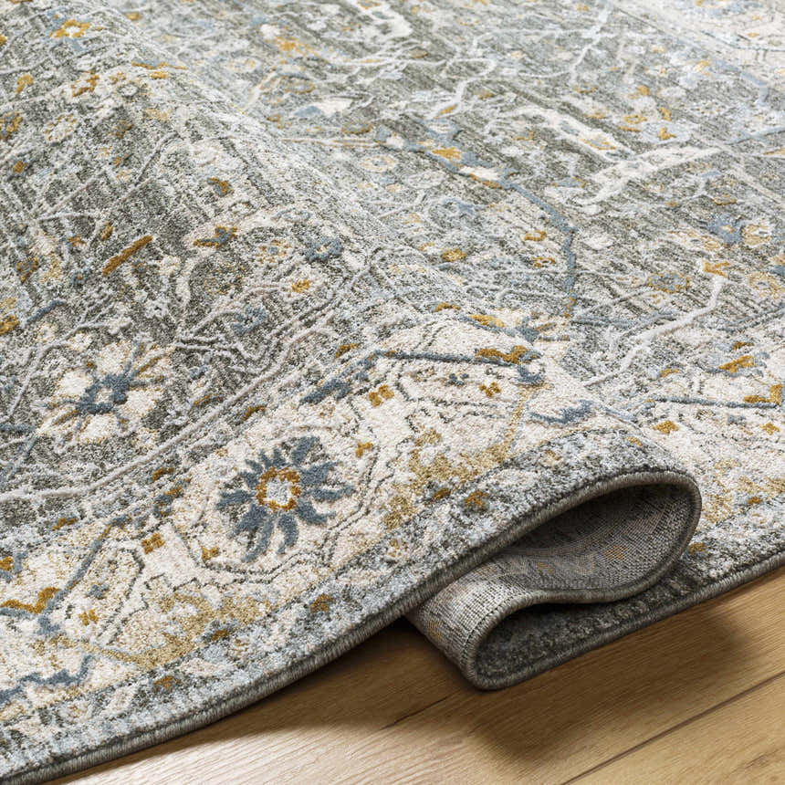 Close-up of the Aviva Teal Textured Rug showing its traditional floral pattern, fringe detail, and soft color palette. Fold