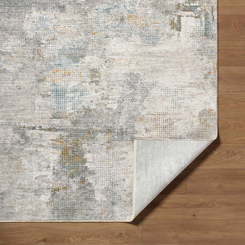 Close-up of the Gryta Textured Rug showing gray, brown, and blue tones with a subtle, distressed contemporary pattern. Fold
