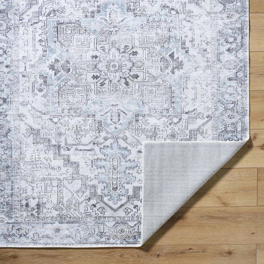 Close-up of Nadia Silver Gray Area Rug showing traditional pattern, light purple, silver gray, and non-slip backing. Fold