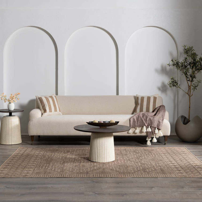 Living room scene with a beige sofa and Halle Beige Washable Area Rug. Farmhouse style with brown geometric patterns. Roomscene-Rectangle