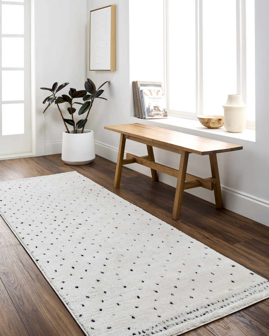 Entryway with a Julie Area Rug runner in beige and black, wood bench, and indoor plant. Roomscene-Runner