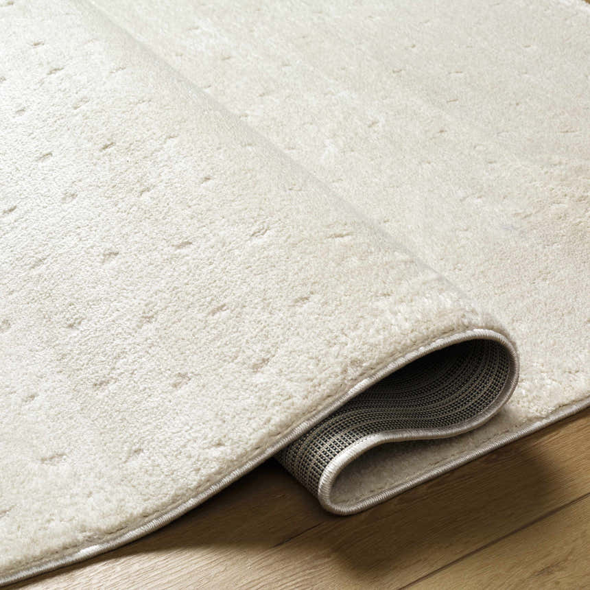 Close-up of the Julie Ivory Area Rug showing the plush texture and subtle beige pattern. Fold