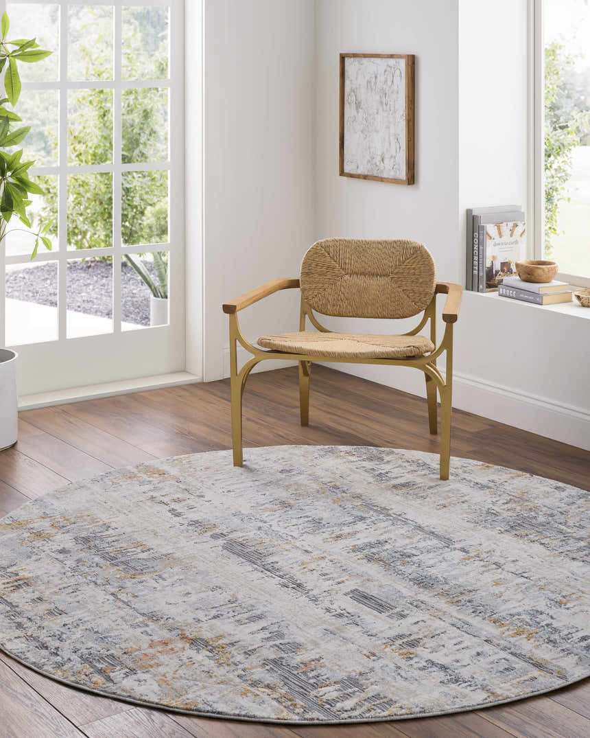 Light and airy room featuring a round Guoda Area Rug in driftwood, gray, and nutmeg tones under a modern woven chair. Roomscene-Round
