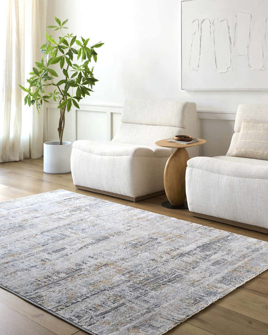Living room scene with a Guoda Area Rug in driftwood, gray, and brown tones, paired with white chairs and light wood floors. Roomscene-Rectangle