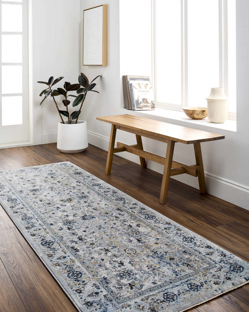 Entryway with a light gray and denim Irida Area Rug, wood bench, and potted plant. Roomscene-Runner