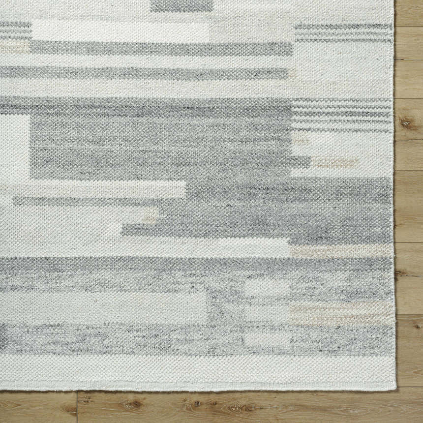 Close up of the Fadri Area Rug. Beige, ivory, and taupe wool rug with a geometric, mid-century modern design. Hand knotted texture. Corner