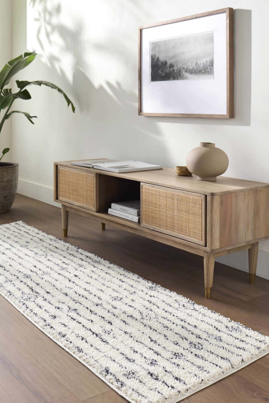 Living room scene with a Demi Beige Washable Area Rug, wood console table, art, and plant. Modern bohemian style. Roomscene-Runner