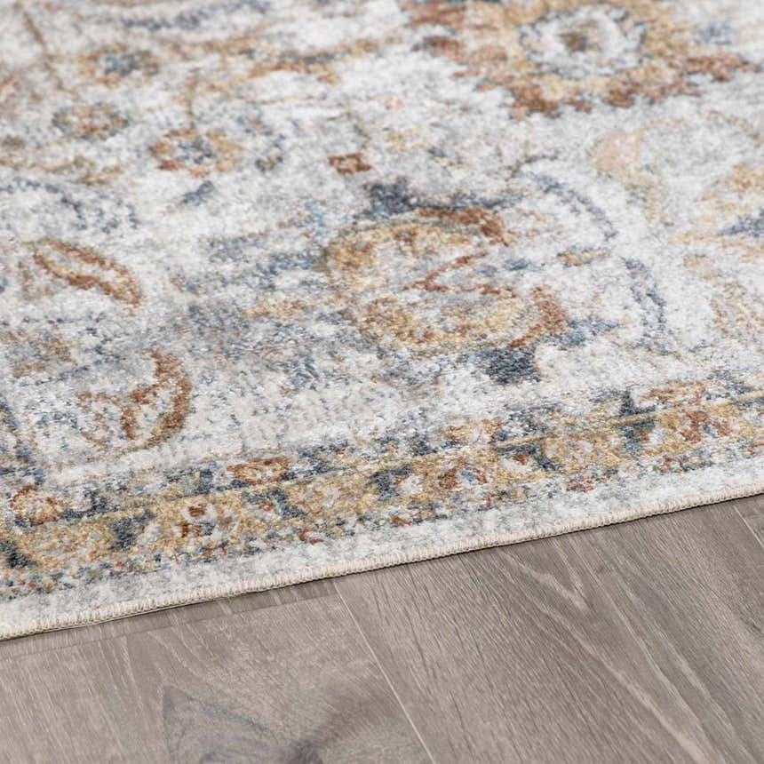 Close-up of the Dion Washable Floral Rug showing its charcoal, beige, and gray traditional pattern and soft texture. Pile