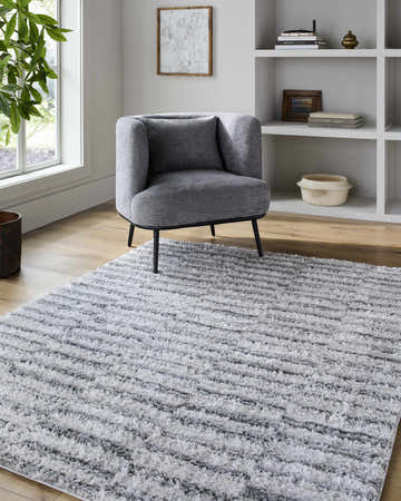 Living room scene with gray chair and Anevay Dark Gray Area Rug. Neutral tones, soft light. Roomscene-Rectangle