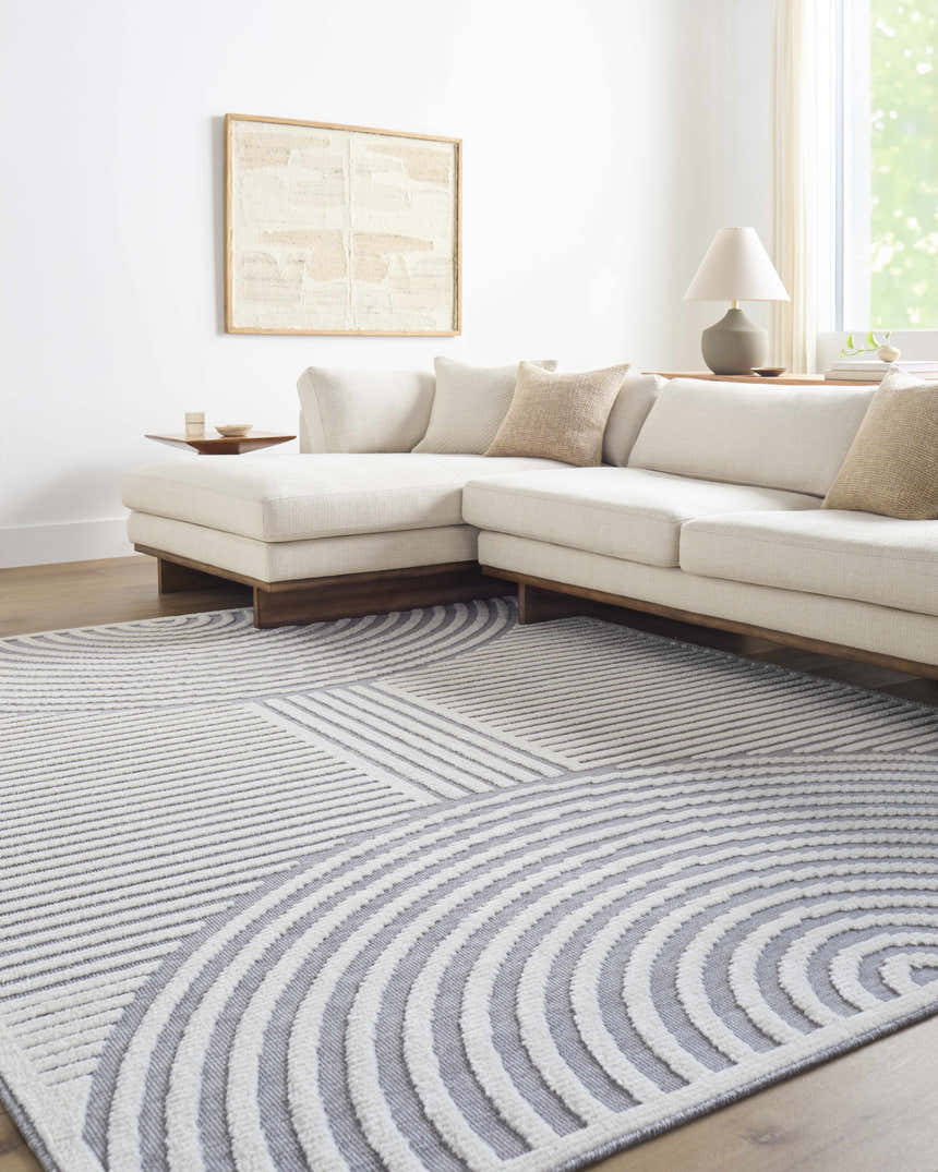 Living room with a gray and white geometric Deron Gray Rainbow Washable Rug under a modern sectional sofa. Roomscene-Rectangle