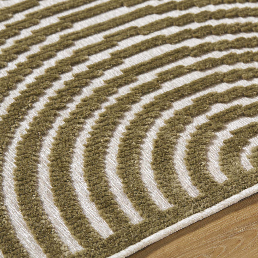 Close-up of the Deron Khaki Washable Area Rug, showcasing its olive and white geometric pattern and soft, textured pile. Texture