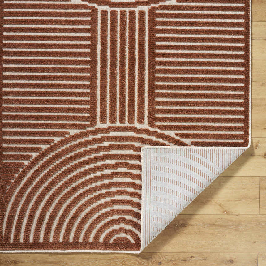 Close-up of the Deron Brown Washable Area Rug showing its brown and white contemporary geometric pattern and machine-woven texture. Fold