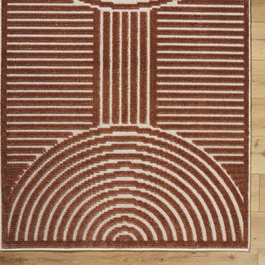 Close-up of the Deron Brown Washable Area Rug. Features a geometric pattern in brown and white on a wood floor. Corner