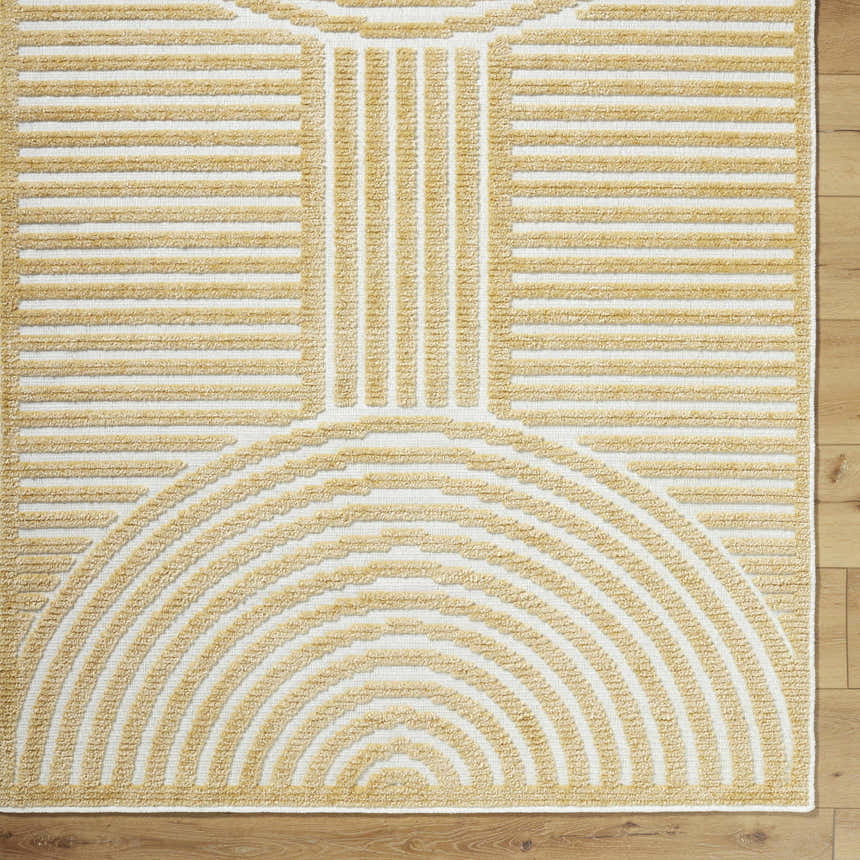 Close-up of Deron Mustard Washable Area Rug. Beige geometric design with semicircle and line patterns on an off-white base. Corner