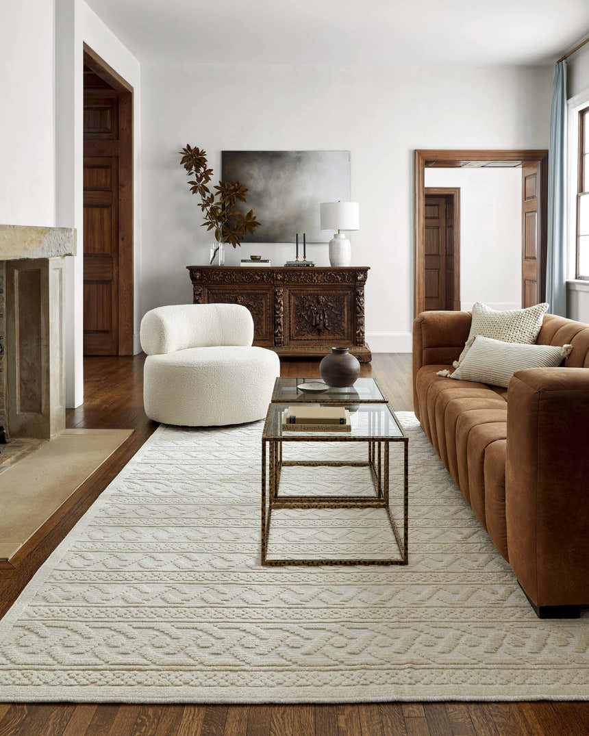 Living room scene with a Fadey White 3D Washable Rug, brown sofa, white chair, and dark wood accents. Roomscene-Rectangle