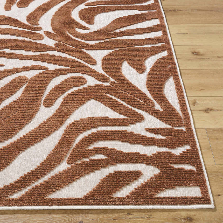 Close-up of the Keto Brown Washable Area Rug with a brown and off white abstract pattern on a wood floor. Front