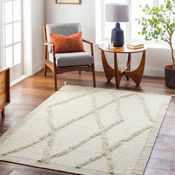 Living room scene with a beige Soto Area Rug, gray chair, and wooden side table. Roomscene-Rectangle