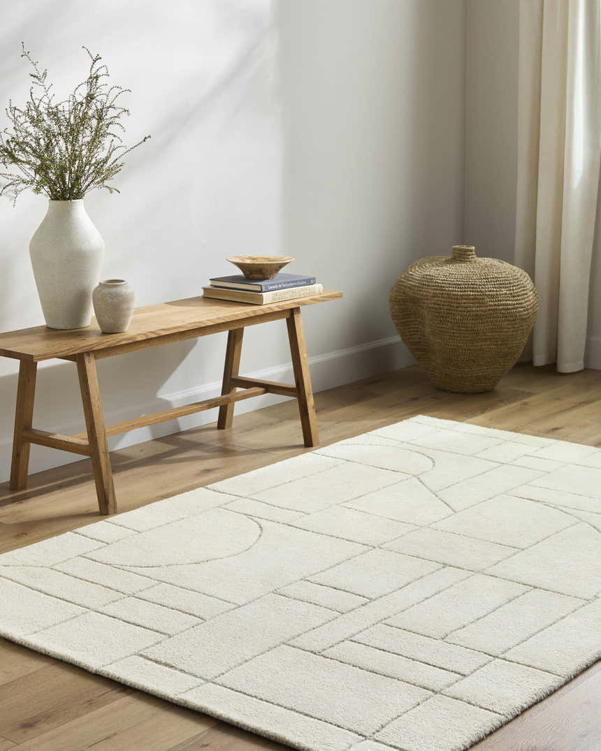 Minimalist room scene with a light wood bench and the off white Fusao area rug with geometric pattern. Roomscene-Rectangle