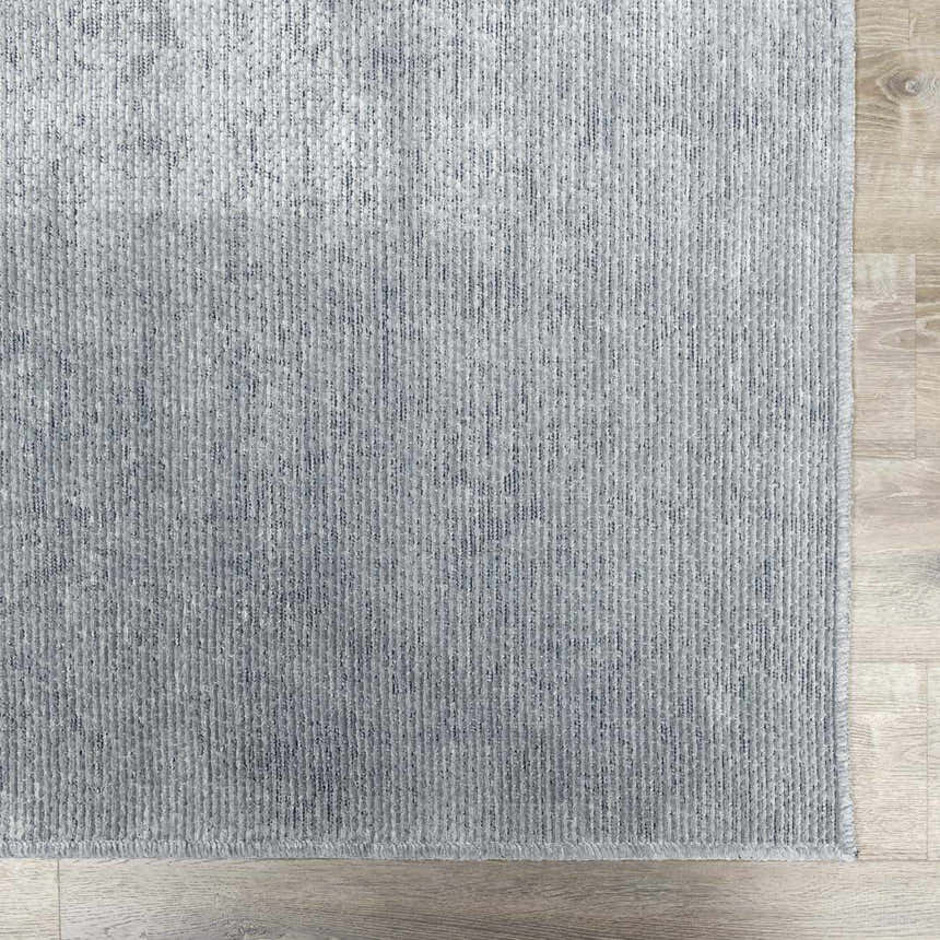 Close-up of the light gray Isako Blue & Gray Solid Washable Area Rug showing texture and machine-woven construction. Swatch
