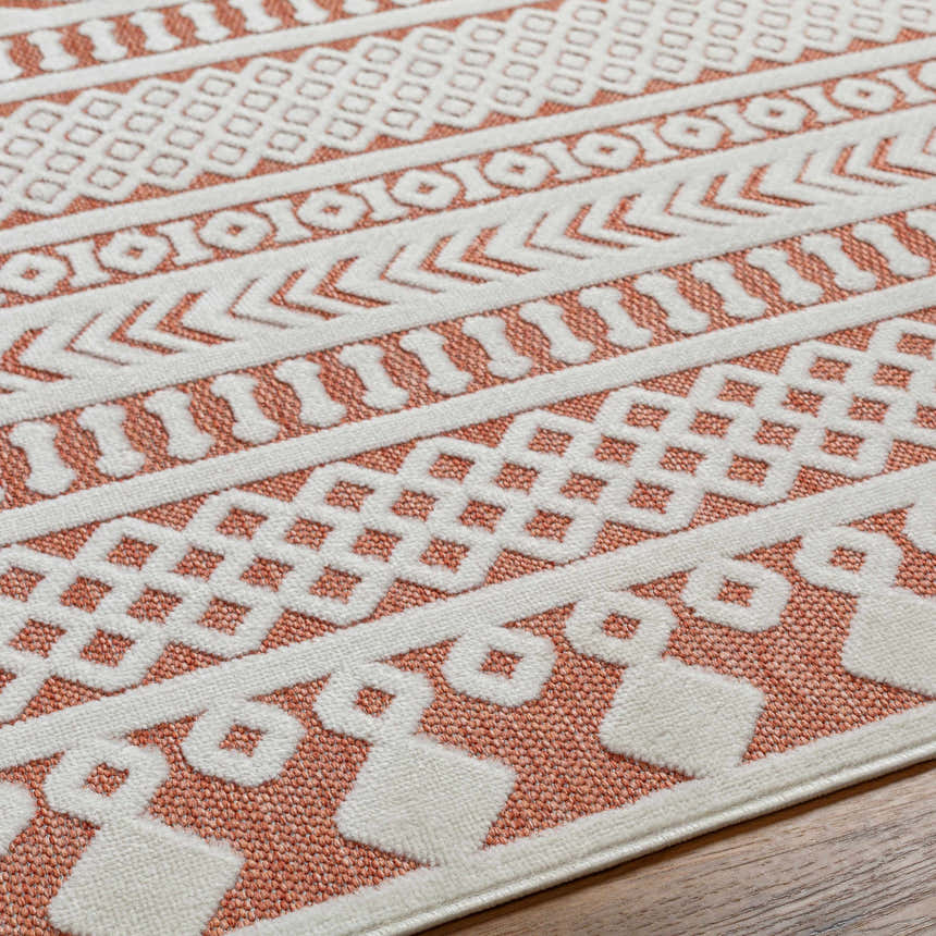 Close up of the Jove Orange Outdoor Rug showing the bone and terracotta geometric pattern. Texture
