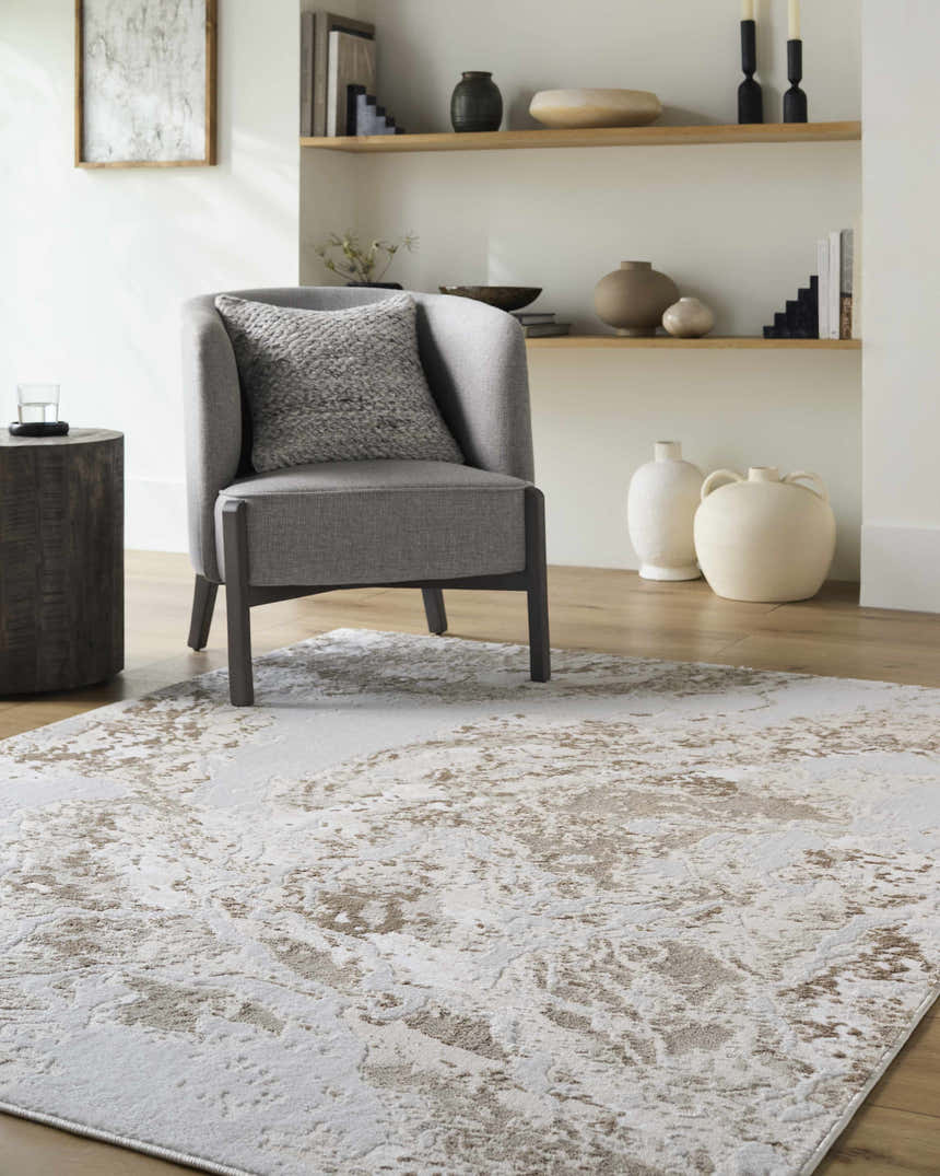 Living room scene with a gray chair on a beige and cream Kaleo Area Rug. Modern decor. Roomscene-Rectangle