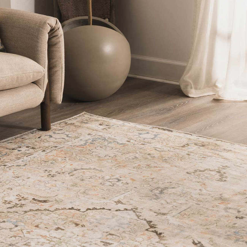 Living room scene with a neutral armchair and Standon Vintage Flat Pile Washable Rug in blue, orange, and beige tones. Texture
