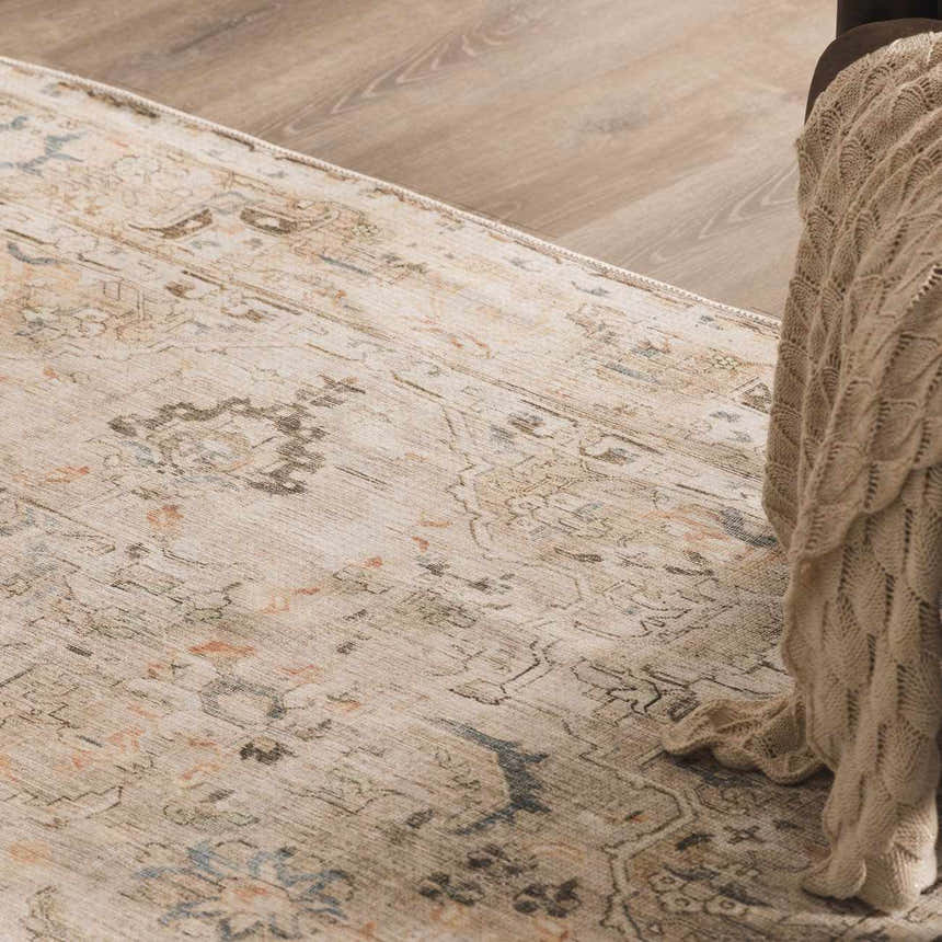 Close-up of the Standon Vintage Flat Pile Washable Rug. Beige rug with a traditional, distressed Persian-style pattern. Styleshot